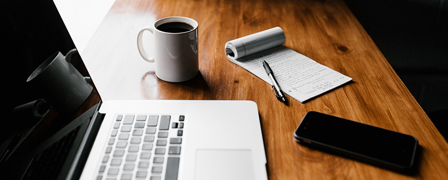 Laptop, notepad, phone, coffee, on desk